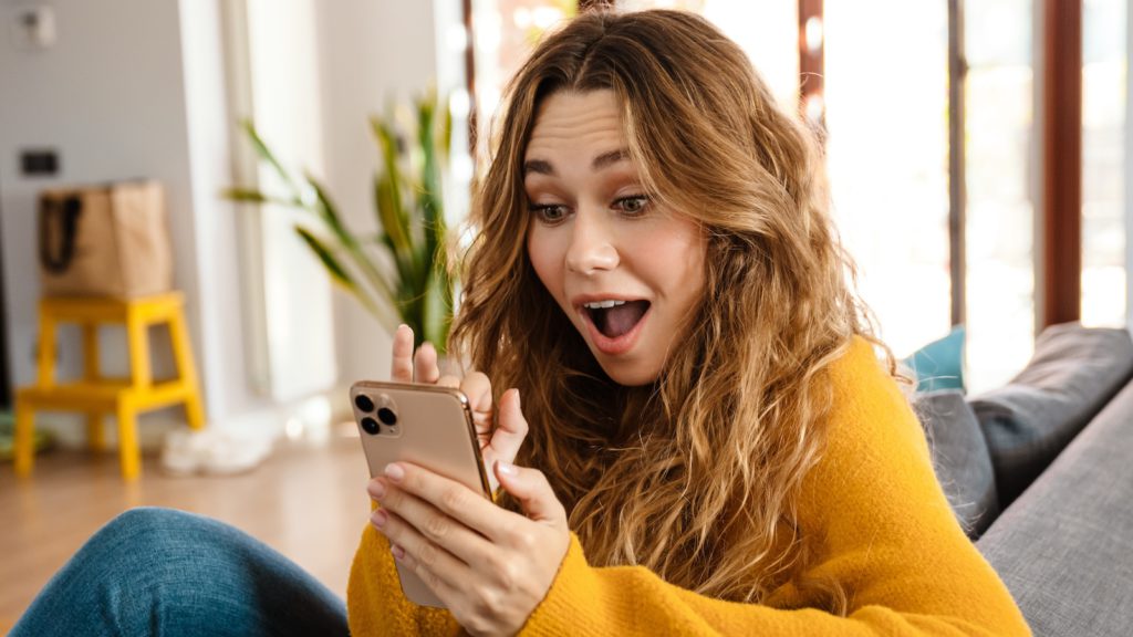 woman looking in surprise at the results of which ai software understands field sales blog on phone
