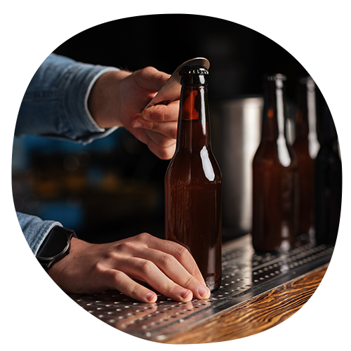 Taking the cap off of a glass bottle of beer